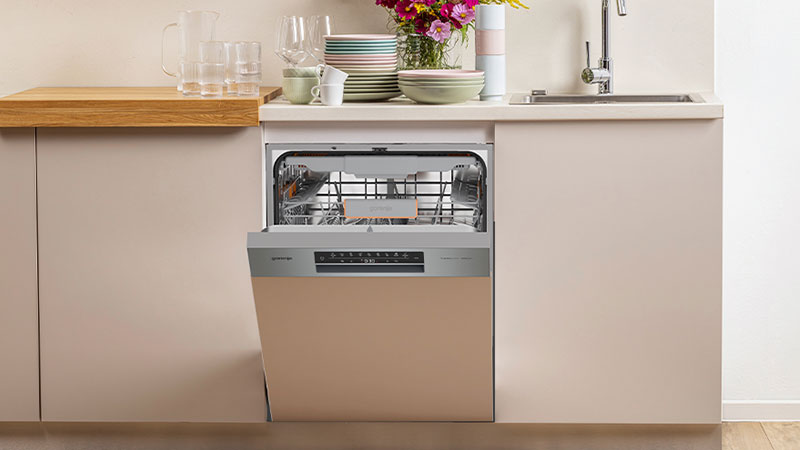 Abbildung: Gorenje Geschirrspüler in moderner Küchenzeile, Tür leicht geöffnet, darüber gestapelte Teller.