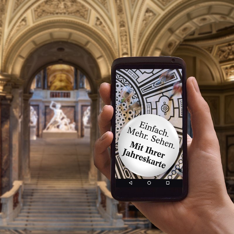 Motiv mit Smartphone im Kunsthistorischen Museum Wien. Auf dem Display steht: „Einfach. Mehr. Sehen. Mit Ihrer Jahreskarte.“